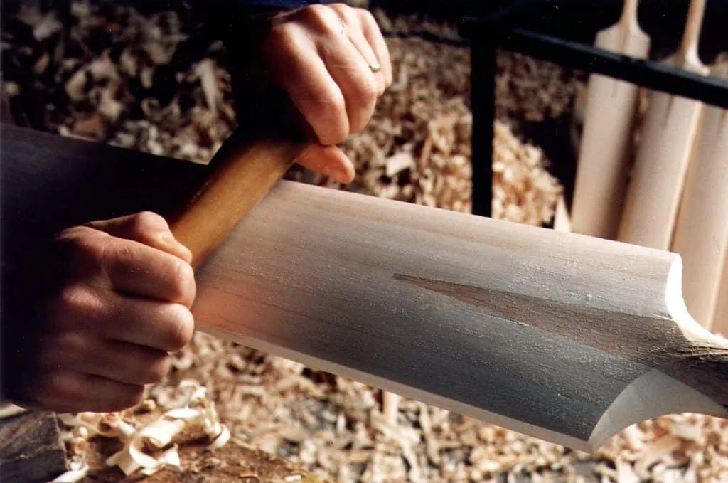 A drawknife shaping the back of a blade