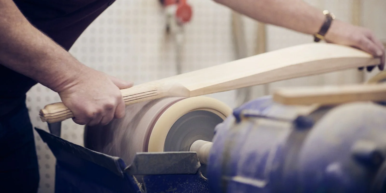 A bat handle being finished on a lathe