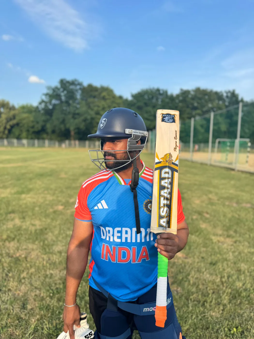 A batter in an India jersey holding an Astaad bat