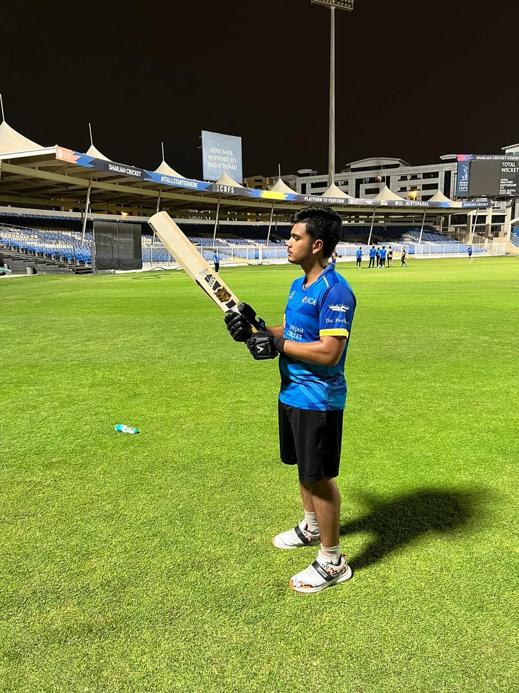 A batter on a floodlit ground with an Astaad bat